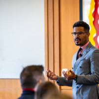 man facilitating a dialogue in full room